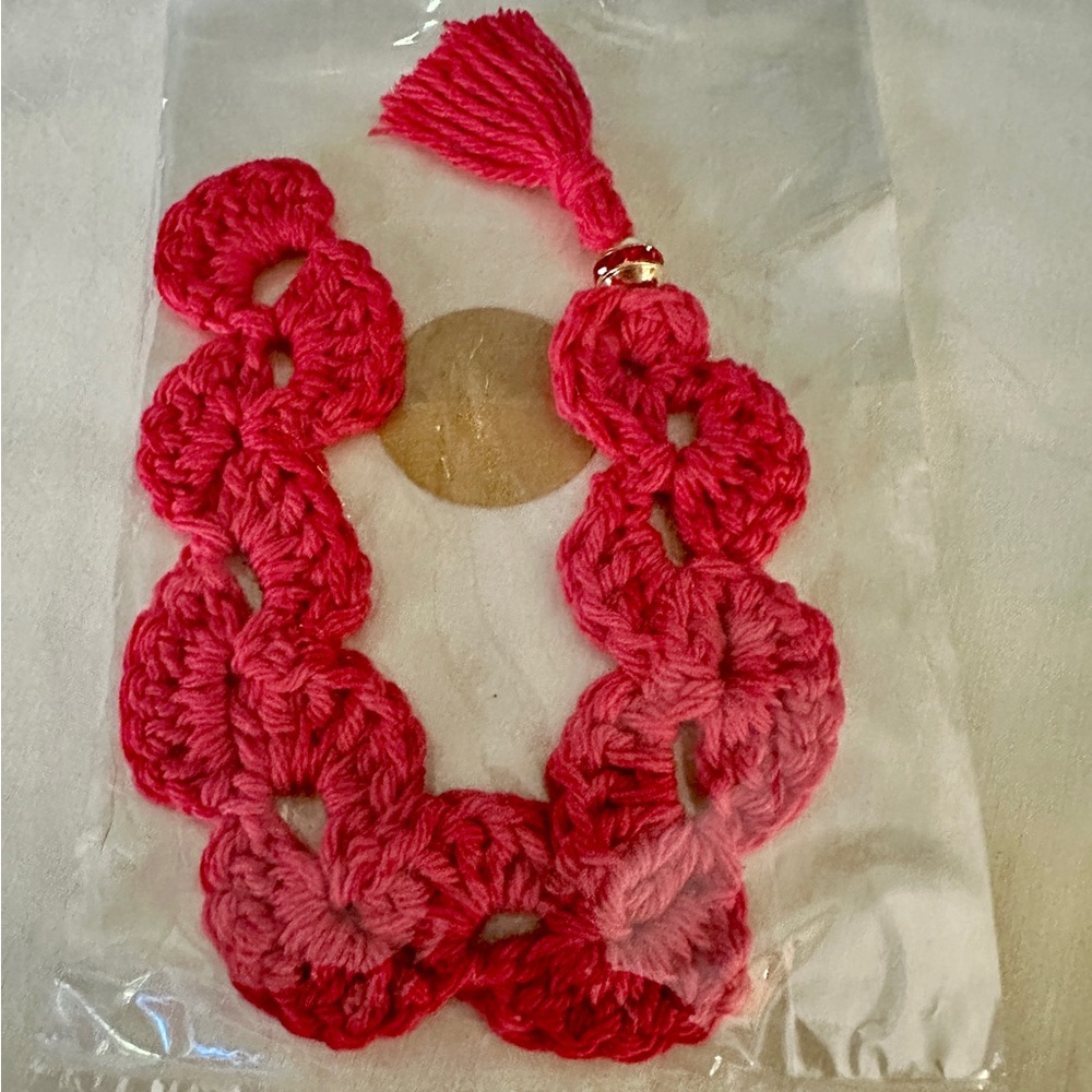 Hand Crocheted Bookmark. With a gold tone and red gem accent.